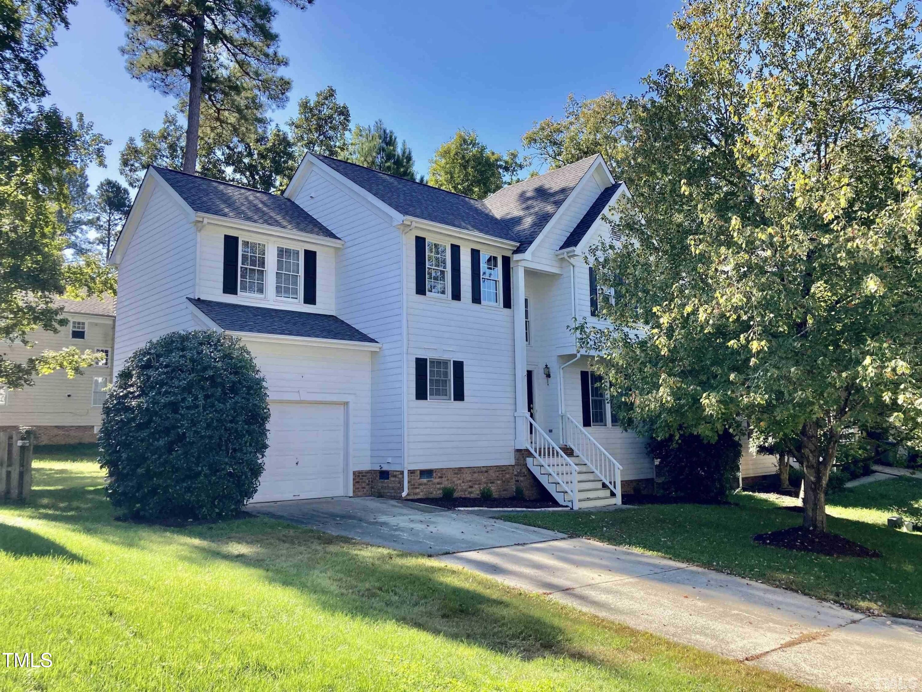 a view of a house with a yard and large tree