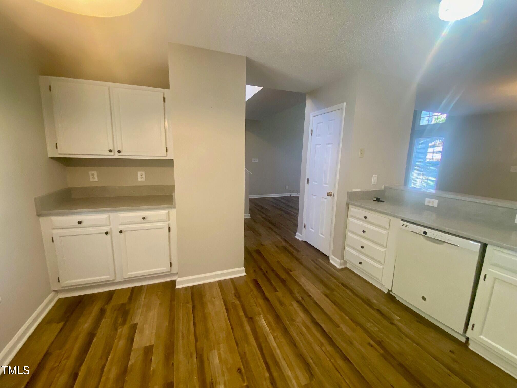 117 Mint Hill Drive Cary, NC 27519 - Photo 5 of 14 a kitchen with white cabinets and wooden floor