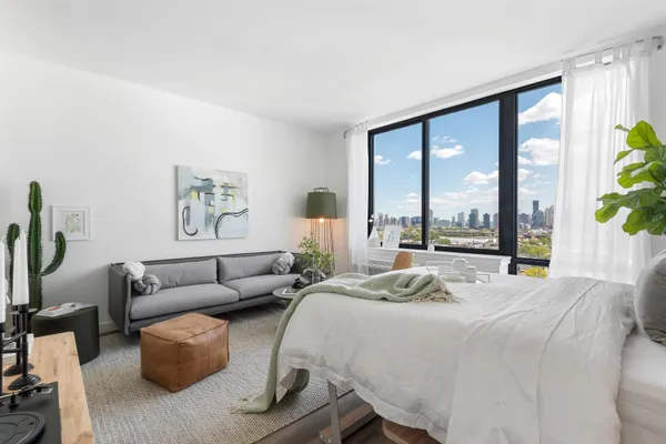 a bedroom with furniture and a large window
