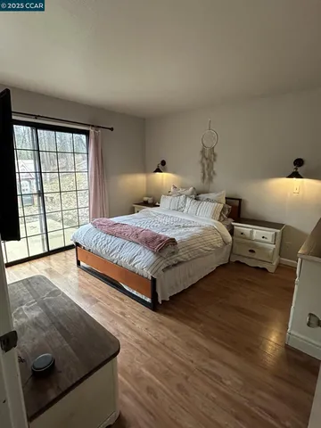 a bedroom with a bed and wooden floor