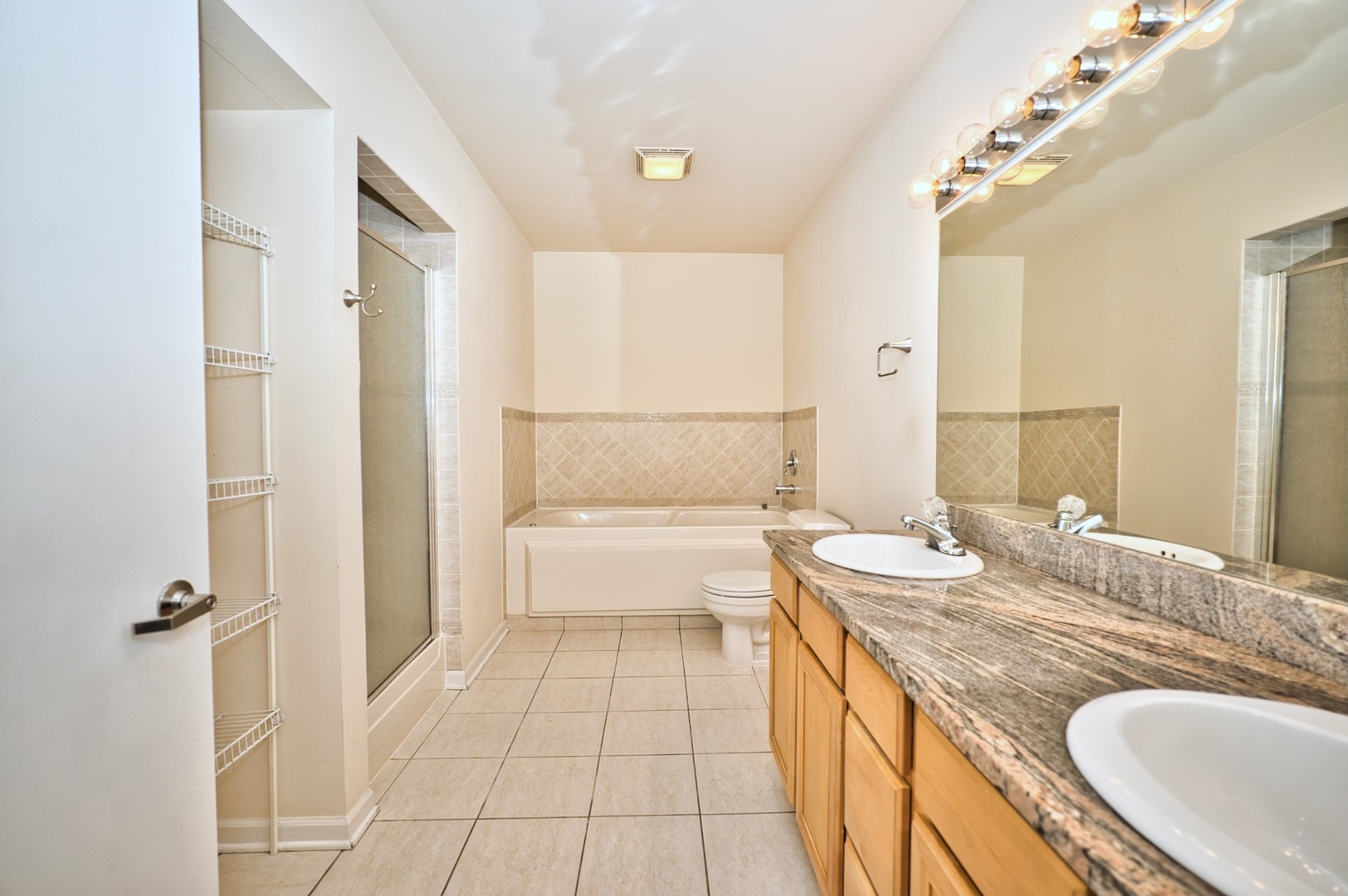 2317 West Wolfram Street, Unit 515 Chicago, IL 60618 - Photo 24 of 35 a spacious bathroom with a granite countertop sink mirror and a bathtub