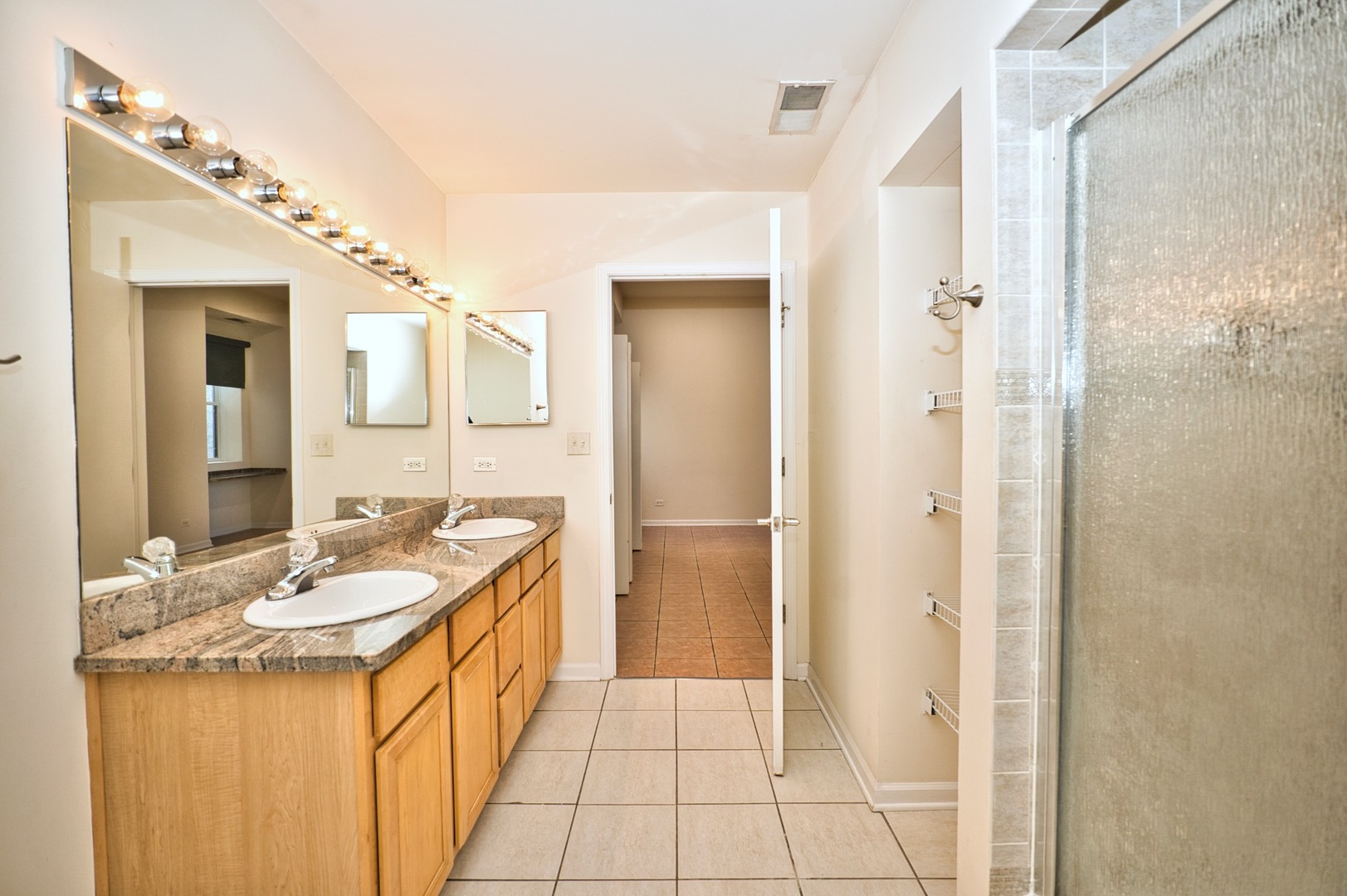 2317 West Wolfram Street, Unit 515 Chicago, IL 60618 - Photo 25 of 35 a spacious bathroom with a granite countertop sink and a mirror