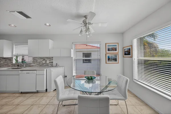a dining room with stainless steel appliances kitchen island granite countertop a dining table and chairs