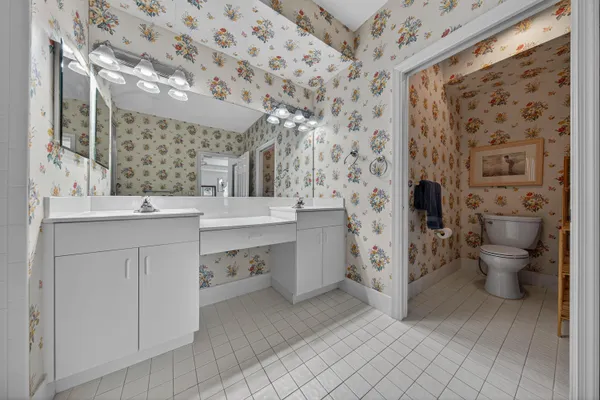 a spacious bathroom with a double vanity sink toilet and shower