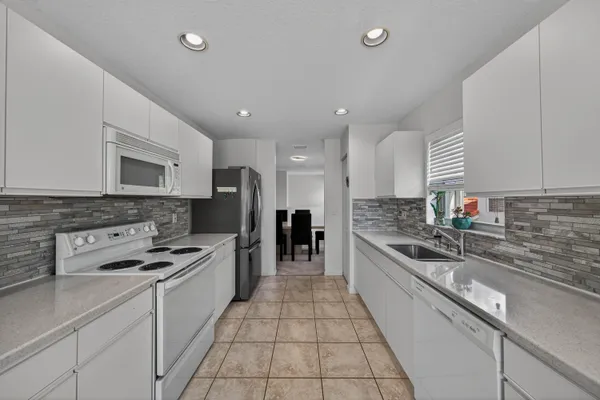 a large kitchen with stainless steel appliances granite countertop a stove and a sink