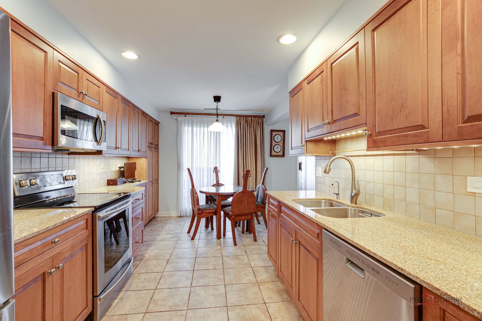 1795 Lake Cook Road, Unit 312 Highland Park, IL 60035 - Photo 8 of 26 a kitchen with granite countertop a sink a counter top space stainless steel appliances and cabinets