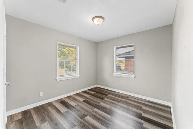a view of a room with wooden floor and windows