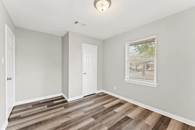 a view of a room with wooden floor and windows