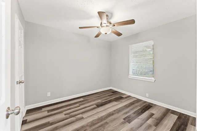 a view of a room with a ceiling fan and a window