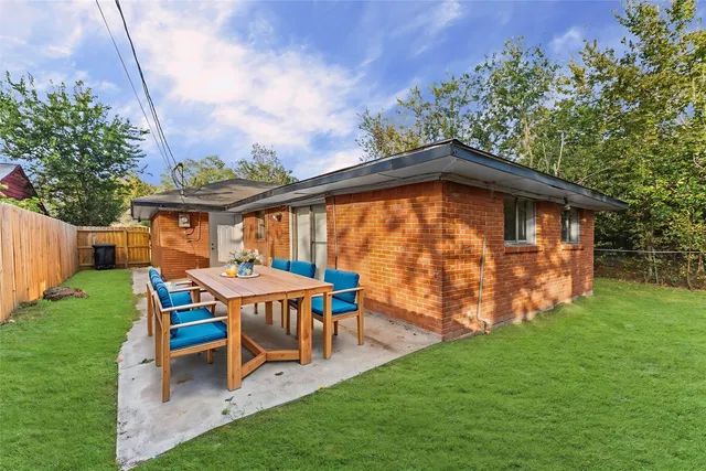 a backyard of a house with table and chairs