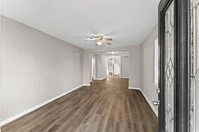 a view of a hallway with a chandelier fan and wooden floor