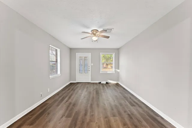 an empty room with a window and a ceiling fan