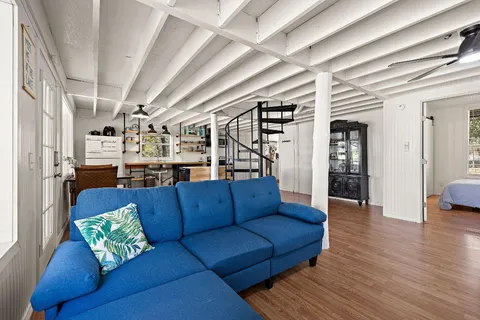 a living room with furniture and wooden floor