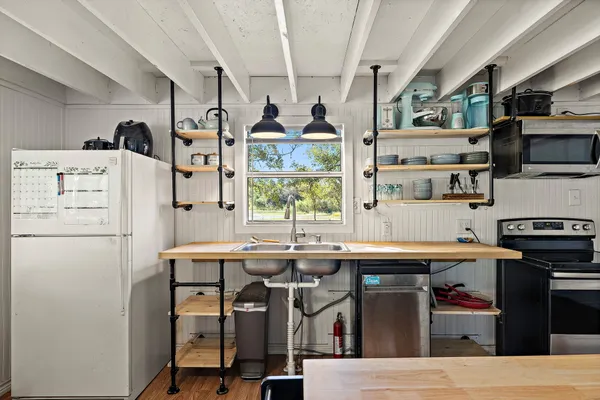 a kitchen with stainless steel appliances a stove a refrigerator and a dining table