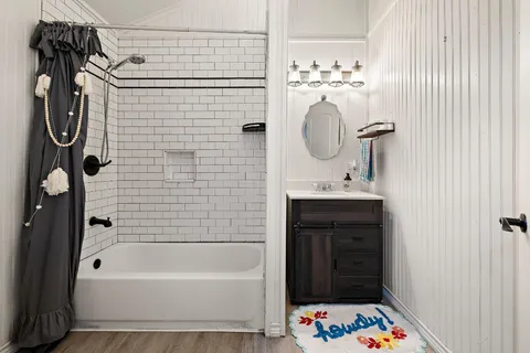 a bathroom with a sink a bathtub and a mirror