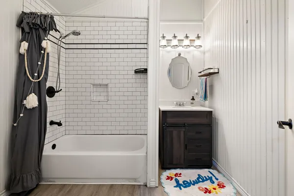 a bathroom with a sink a bathtub and a mirror