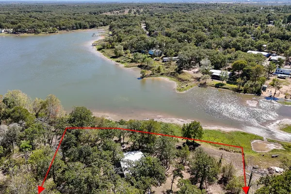 an aerial view of lake and residential houses with outdoor space