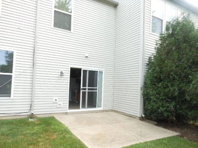 a view of a white house with a yard and potted plants