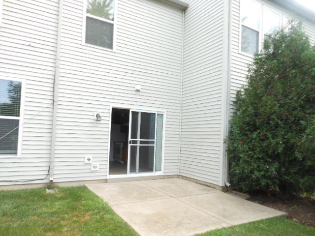 603 Conservatory Lane Aurora, IL 60502 - Photo 17 of 18 a view of a white house with a yard and potted plants