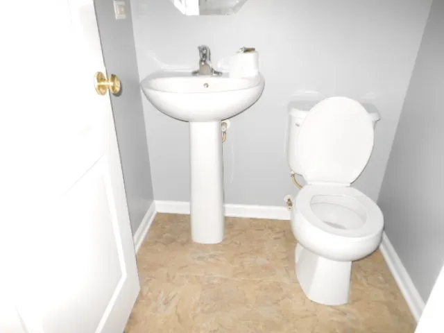 a bathroom with a sink toilet and a mirror