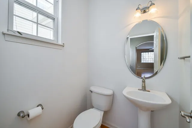 a bathroom with a toilet a sink and a mirror