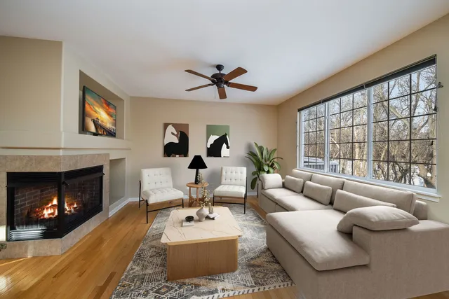 a living room with furniture a fireplace and a large window