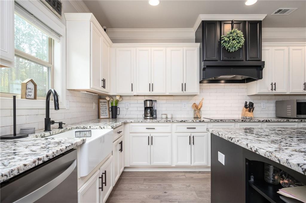 4575 Birch Way Loganville, GA 30052 - Photo 14 of 40 a kitchen with stainless steel appliances granite countertop a sink stove and cabinets