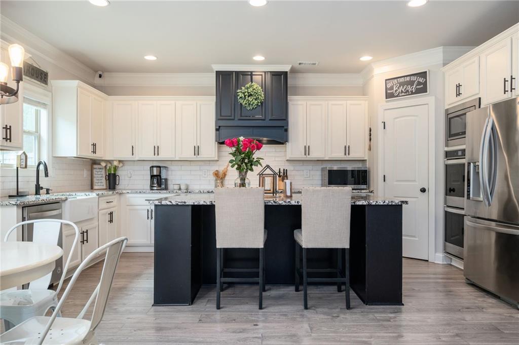 4575 Birch Way Loganville, GA 30052 - Photo 16 of 40 a kitchen with refrigerator cabinets dining table and chairs