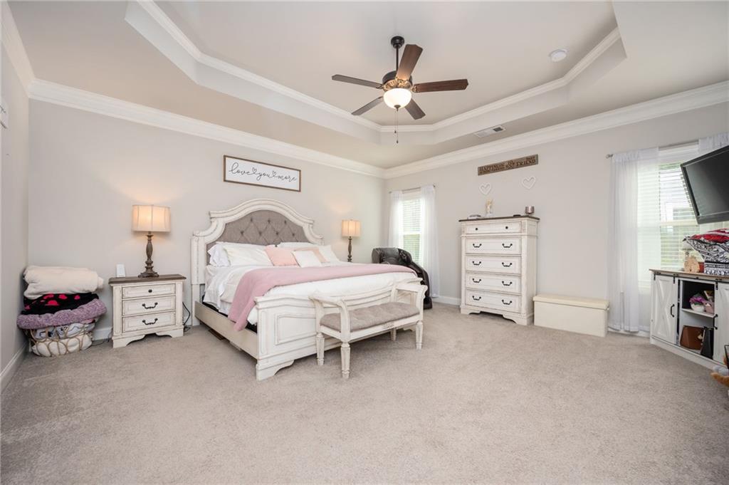 4575 Birch Way Loganville, GA 30052 - Photo 19 of 40 a spacious bedroom with a bed and a ceiling fan
