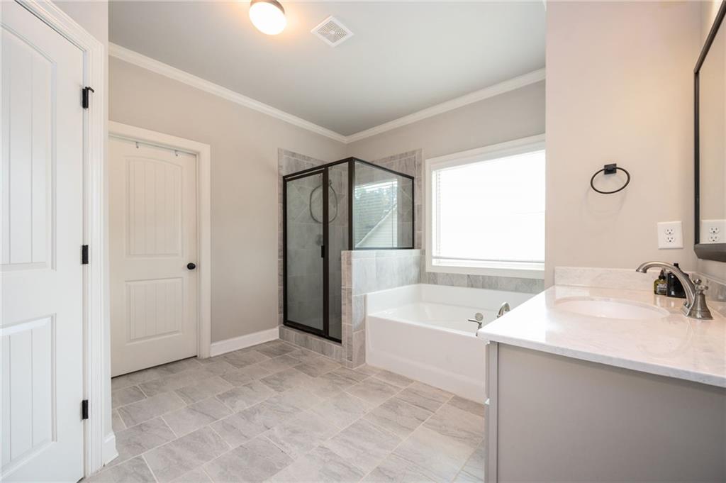 4575 Birch Way Loganville, GA 30052 - Photo 21 of 40 a bathroom with a tub sink and mirror