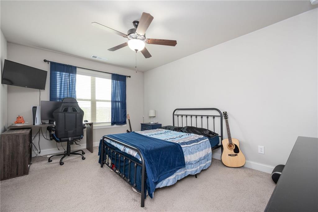 4575 Birch Way Loganville, GA 30052 - Photo 24 of 40 a bedroom with a bed a chandelier and a couch