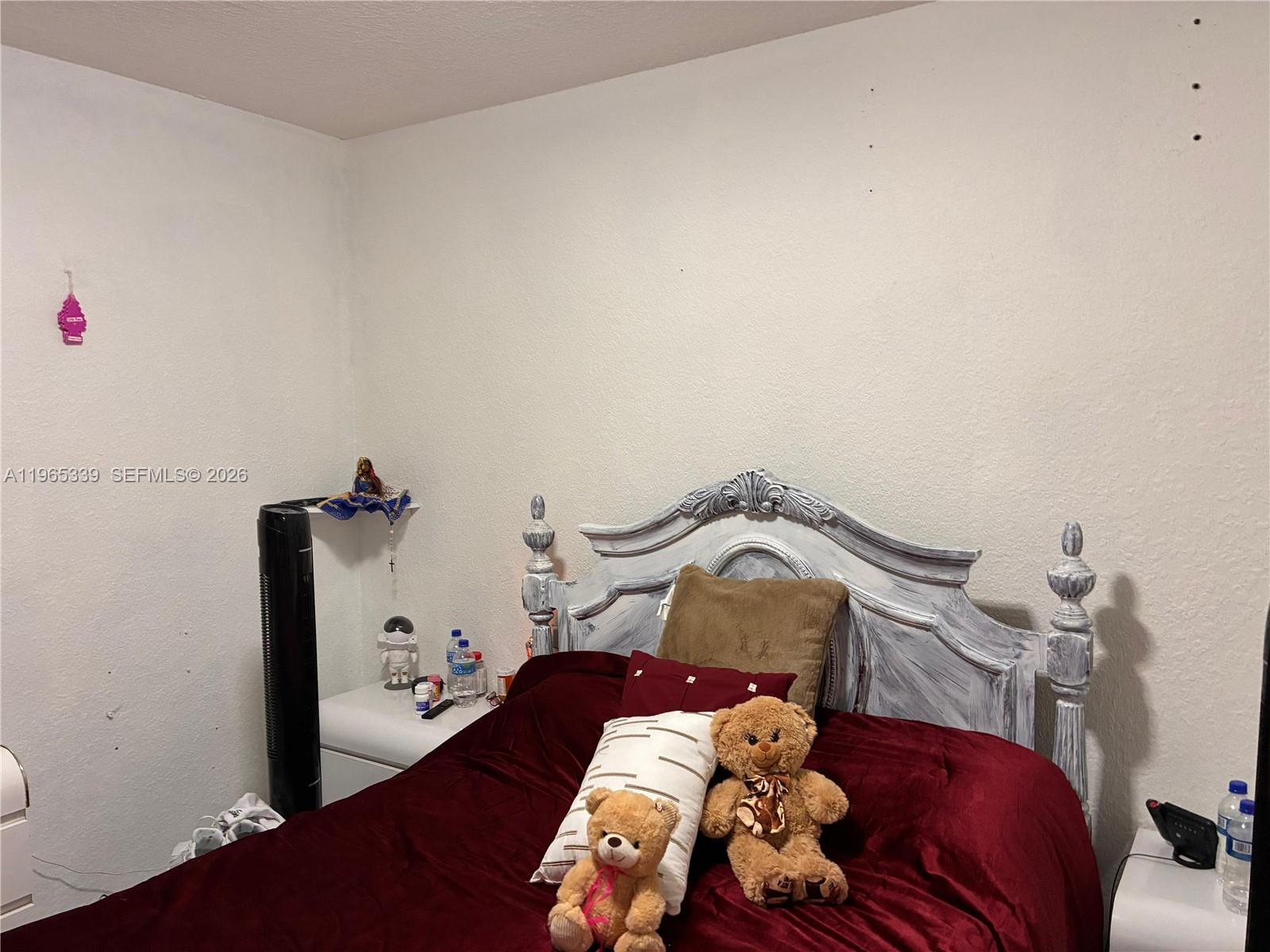 1900 West 68th Street, Unit G103 Hialeah, FL 33014 - Photo 13 of 20 a bedroom with a bed and a chandelier