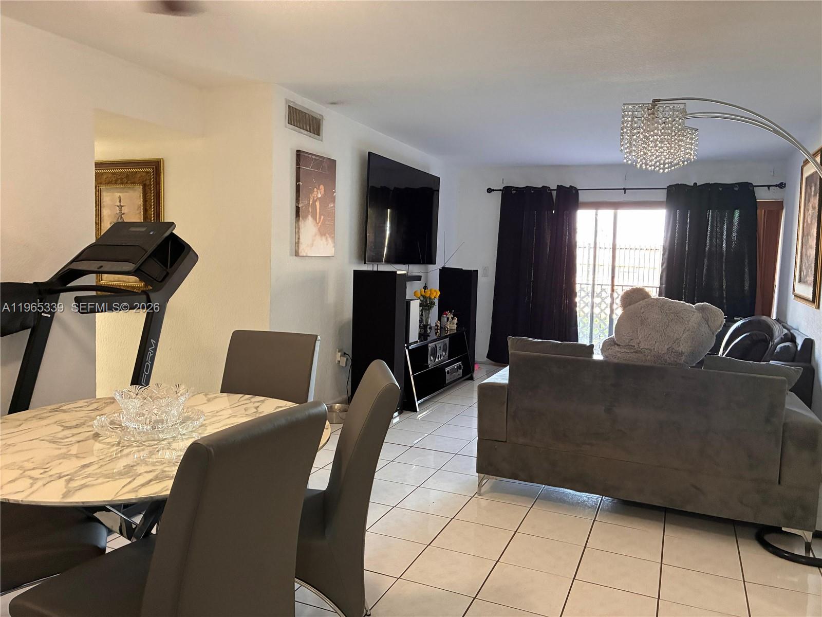 1900 West 68th Street, Unit G103 Hialeah, FL 33014 - Photo 6 of 20 a living room with furniture and a flat screen tv