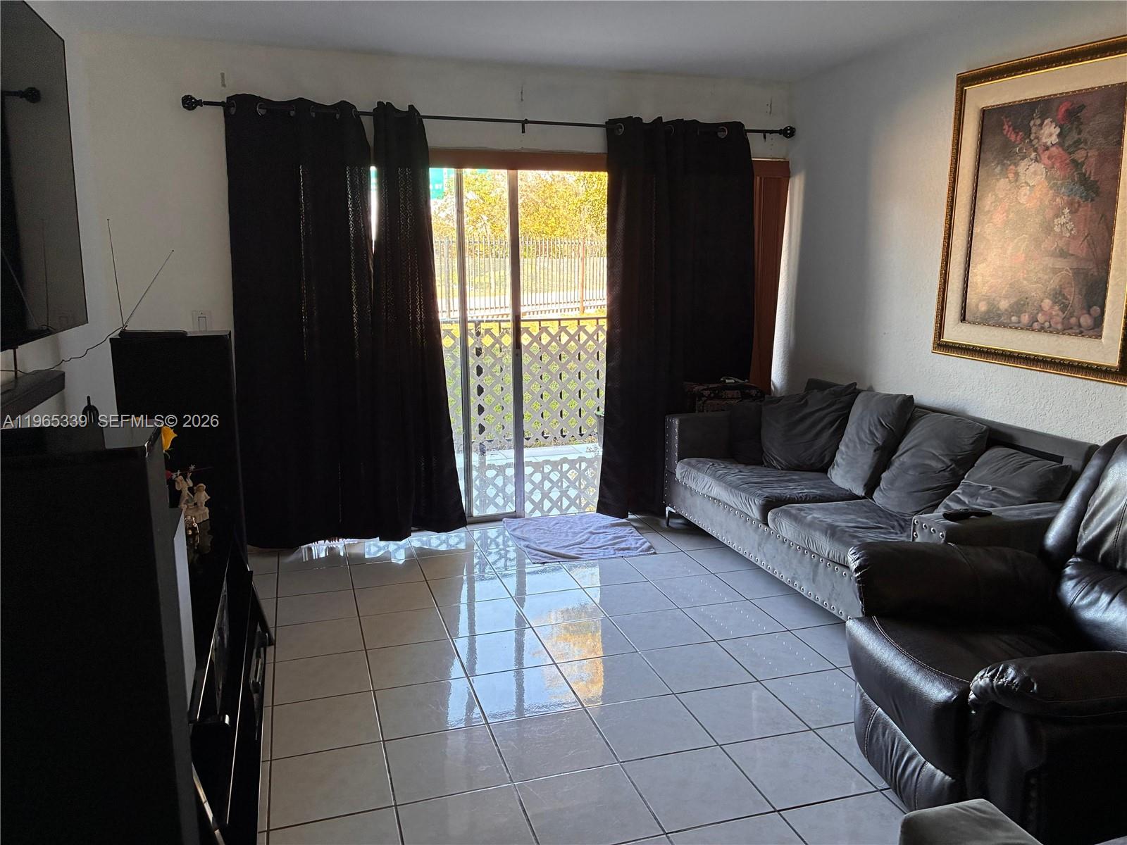 1900 West 68th Street, Unit G103 Hialeah, FL 33014 - Photo 8 of 20 a living room with furniture and a flat screen tv
