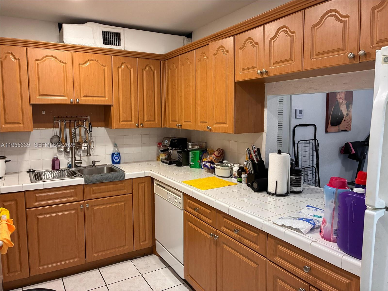 1900 West 68th Street, Unit G103 Hialeah, FL 33014 - Photo 9 of 20 a kitchen with a sink cabinets and appliances