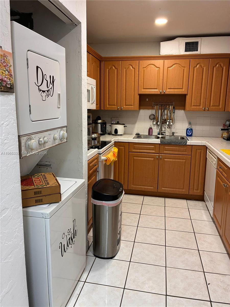 1900 West 68th Street, Unit G103 Hialeah, FL 33014 - Photo 10 of 20 a kitchen with a sink a stove and cabinets