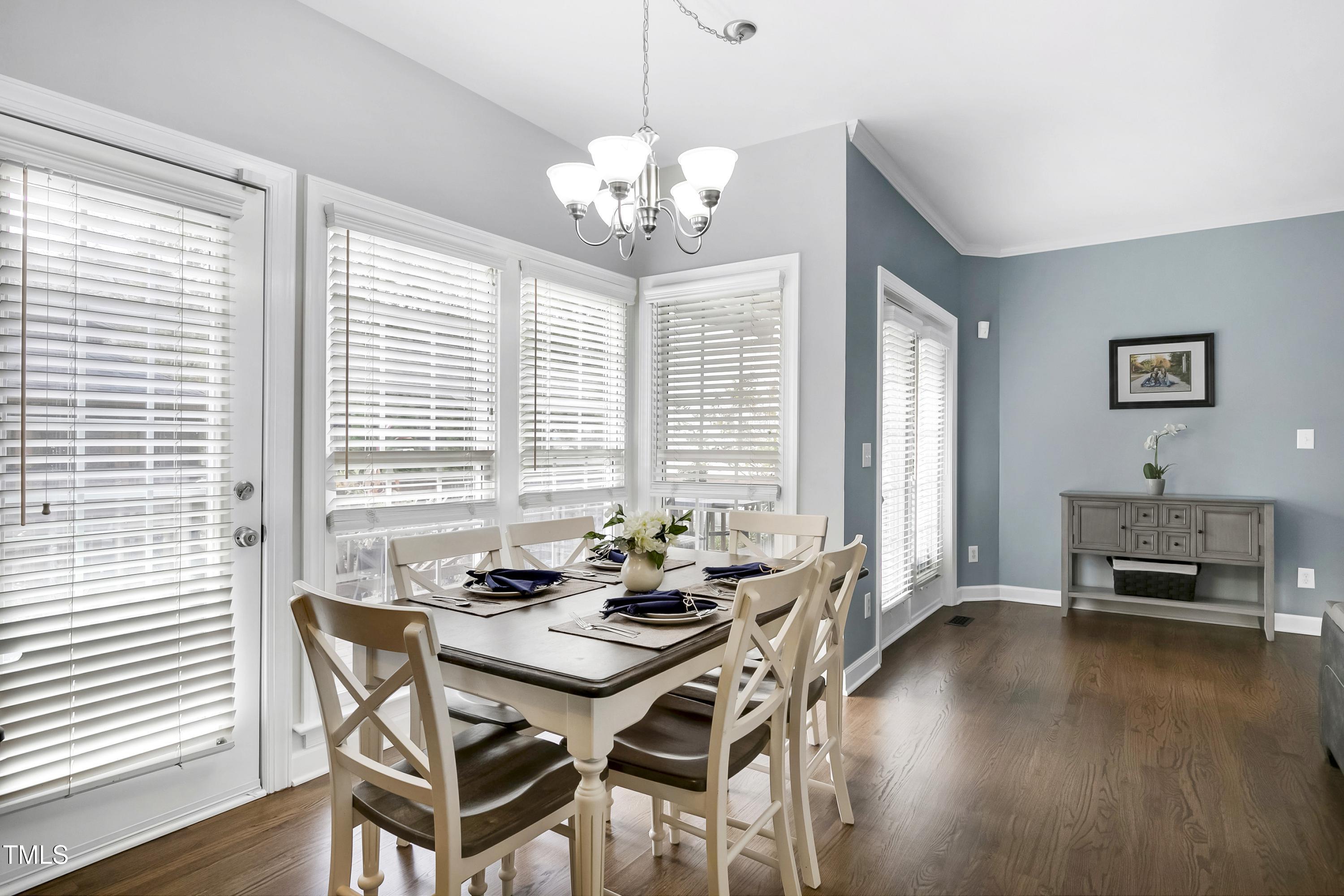 102 Kenneil Court Apex, NC 27502 - Photo 13 of 55 a dining room with wooden floor and large windows