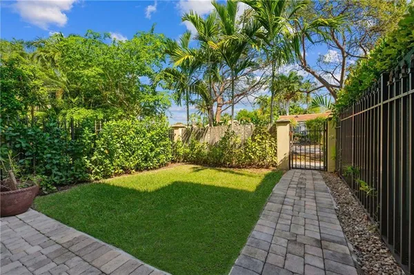 a view of a backyard with potted plants and large trees