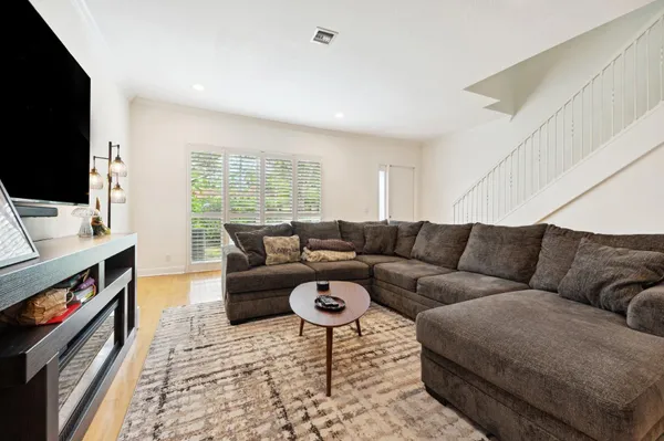a living room with furniture a flat screen tv and a fireplace