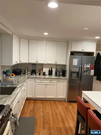 a kitchen with sink refrigerator and cabinets