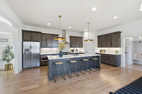a large kitchen with granite countertop a large counter top stainless steel appliances and cabinets