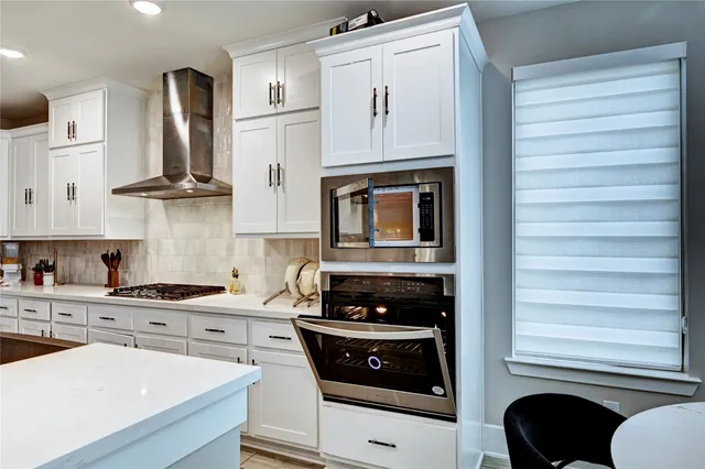 a kitchen with stainless steel appliances granite countertop a sink stove and cabinets