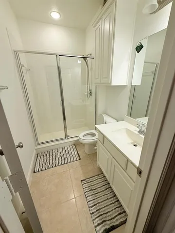 a bathroom with a sink a toilet a mirror and shower