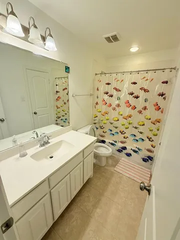 a spacious bathroom with a shower sink and mirror