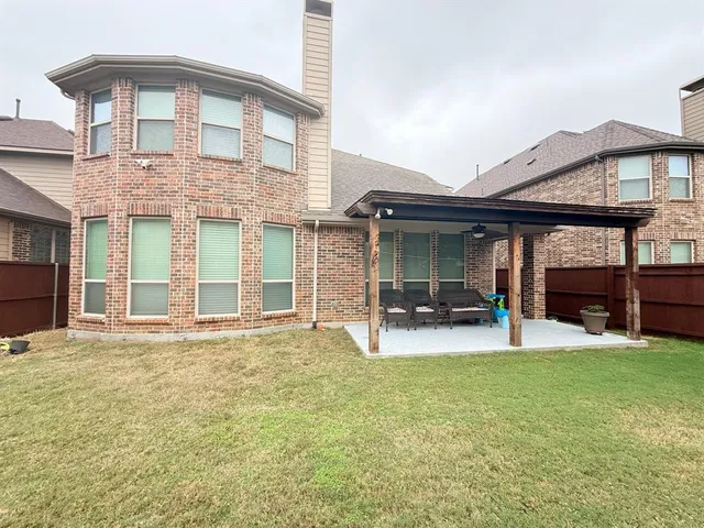 a view of a house with patio and a yard