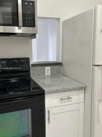 a kitchen with granite countertop cabinets and a stove