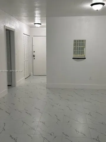 an empty room with entrance and windows