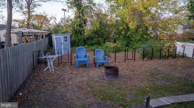 a view of a backyard with table and chairs and wooden fence