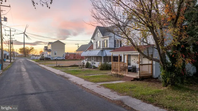 a front view of a house with yard porch and tree