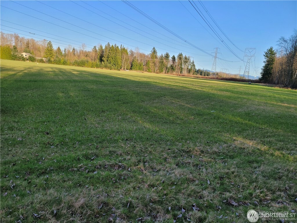 a view of a field of grass and covered with wooden fence